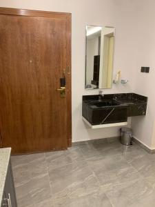 a bathroom with a black sink and a mirror at شقق كالم الفندقية in Riyadh