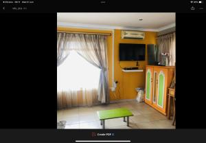 a living room with a window and a green stool at JimmyLuh Garden Cottage in Durban