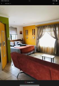 a hotel room with two beds and a window at JimmyLuh Garden Cottage in Durban