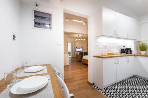 a kitchen and dining room with white cabinets and a table at Quiet Apartment with a Garden at Exarcheia in Athens