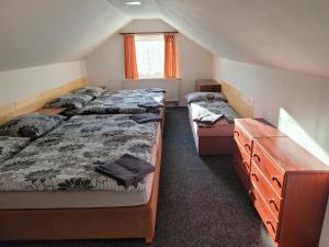 a bedroom with two beds and a dresser in it at Penzion Karolína in Lučany nad Nisou