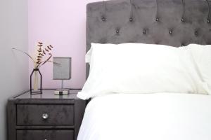 a bedroom with a bed with white pillows and a night stand at Cohost Partners: Perfect Retreat in Bristol in Bristol