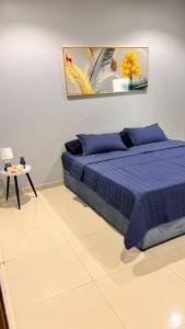 a bedroom with a blue bed and a table at Elegant apartment in Jeddah