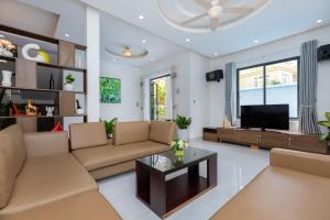 a living room with a couch and a tv at Hoàng My Villa D3 in Vung Tau