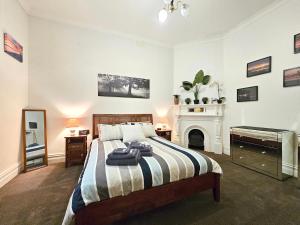1 dormitorio con 1 cama y chimenea en Unley Retreat, en Unley