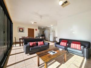 a living room with two black couches and a table at Unley Retreat in Unley