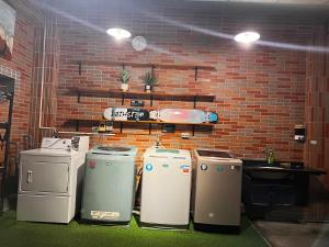 a group of refrigerators lined up against a brick wall at 森林寓 in Minxiong