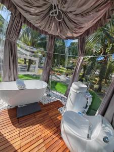 La salle de bains est pourvue d'une baignoire et de toilettes sur une terrasse. dans l'établissement The Coco Journey - Eco Dome, à Malacca