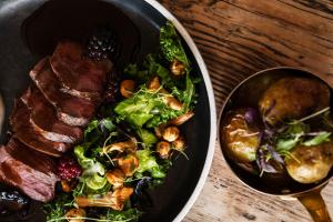 um prato de comida com carne e uma salada em Sundvolden Hotel em Sundvollen