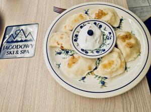 une assiette de nourriture avec un beignet au-dessus dans l'établissement Jagodowy Ski & Spa, à Lasowka
