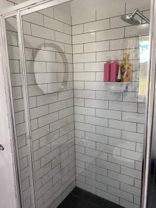 a bathroom with a shower with white tiled walls at The Sugarloaf Homestead in Kyoomba +26 photos