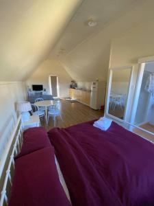 a bedroom with a purple bed and a table at The Sugarloaf Homestead in Kyoomba