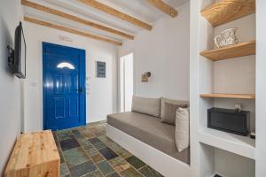 a room with a blue door and a couch at Bella Vista Stegna in Archangelos