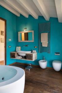 Baño azul con 2 lavabos y bañera en Ca' del Buso, en Verona