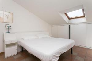 a white bedroom with a white bed and a window at N212 - Numana, quadrilocale in centro con terrazzo in Numana