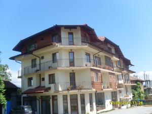 a large white building with balconies on top of it at Hotel Gazei in Bansko