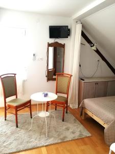 een woonkamer met een tafel en 2 stoelen bij Zsuzsanna Vendégház in Gyomaendrőd