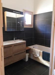 a bathroom with a tub and a sink and a bath tub at Individual chalet for up to 12 people maximum in Les Contamines-Montjoie