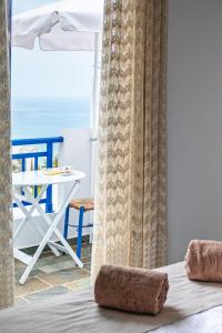 a bedroom with a bed and a table and a chair at Bella Vista Stegna in Archangelos