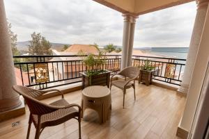 Un balcón con sillas y mesas y vistas al océano. en INGANZO BOUTIQUE HOTEL en Kigali