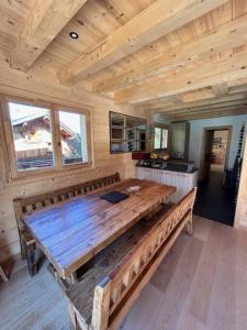 a large wooden table in a cabin with a kitchen at Individual chalet for up to 12 people maximum in Les Contamines-Montjoie