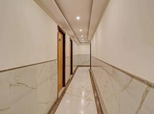 a hallway with white marble walls and a door at OYO Townhouse 843 Stay Inn in New Delhi