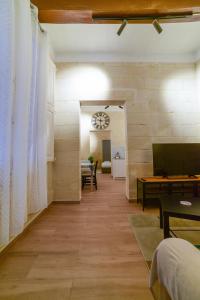 a hallway with a living room with a table and a clock at Valletta Collection - Felix Apartments in Valletta