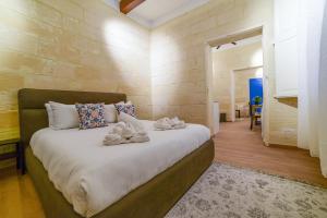 a bedroom with a large bed with towels on it at Valletta Collection - Felix Apartments in Valletta