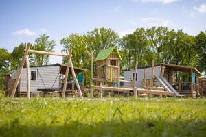 un grupo de casas de juego y diapositivas en un parque en Camping Marvilla Parks Kaatsheuvel - Roan en Kaatsheuvel