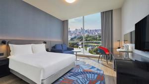 a hotel room with a bed and a large window at Holiday Inn Express Taichung Park, an IHG Hotel in Taichung