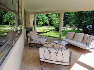 a screened in porch with a couch and chairs at Le Jardin du Dolaizon in Le Puy en Velay