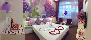 Tuong Vi Hotel في هاي فونج: غرفة نوم عليها سرير بقلوب