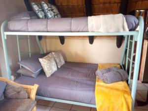 - deux lits superposés avec un canapé dans l'établissement Mountain Haven Hideaway, à Buffelspoort