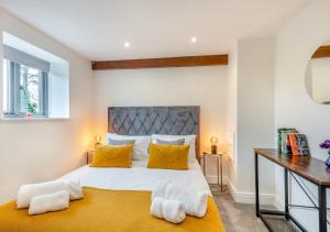a bedroom with a large bed with yellow pillows at Swallows Barn in Little Snoring