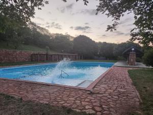 a swimming pool with a fountain in the middle at Mountain Haven Hideaway in Buffelspoort