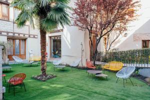 eine Gruppe Stühle und ein Baum im Hof in der Unterkunft Hotel Cetina Palacio Ayala Berganza in Segovia