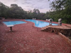 a swimming pool with a stone wall around it at Mountain Haven Hideaway in Buffelspoort