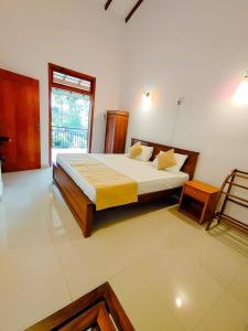 een slaapkamer met een groot bed en een raam bij Virahi Villa in Wadduwa