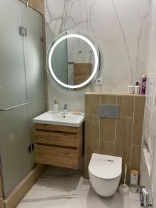 bagno con servizi igienici, lavandino e specchio di ЖК Три короны ad Aqtau