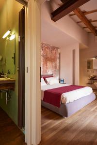 um quarto com uma cama e uma casa de banho com um lavatório em Bright and Peaceful Apartment in Historic Palazzo em Bolonha
