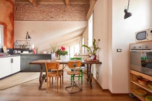 uma cozinha com mesa e cadeiras num quarto em Bright and Peaceful Apartment in Historic Palazzo em Bolonha