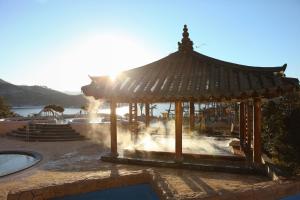 Jungheung Gold Spa & Resort في Naju: شرفة مع نافورة مائية في الحديقة