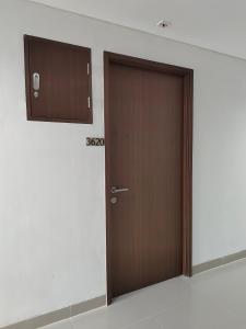 eine Holztür in einem Zimmer mit einer Wand in der Unterkunft Trans Park Juanda Bekasi By MJ Room in Padurenan