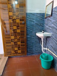 a bathroom with a sink and a mirror and a bucket at Campcee by Gokarna Adventure in Gokarna