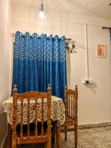 ein Schlafzimmer mit einem blauen Vorhang und einem Kinderbett in der Unterkunft Bliss Studio’s - Entire 1 BHK Apartment in Nagpur