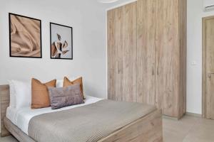 Schlafzimmer mit einem Bett und einem Holzschrank in der Unterkunft Phaedrus Living: Eolus Residences Artemis in Strovolos