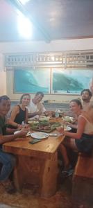 a group of people sitting at a table eating food at Nias Shady Palm surfcamp in Lagudri