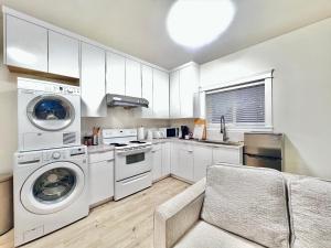 uma cozinha com electrodomésticos brancos e um sofá em Si & Daniel Home Near YVR Airport & Skytrain Separate Entry Free Parking em Richmond