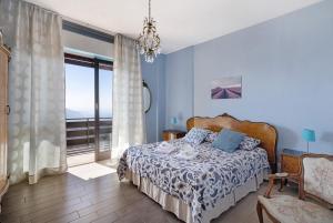 a blue bedroom with a bed and a balcony at Appartamento Bella Vista in Premeno