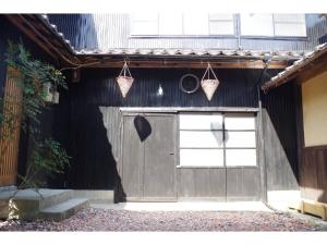 a garage with a door and two hanging baskets at base sanablend - Vacation STAY 37411v in Kyotango